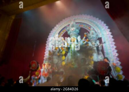 Immagine offuscata di fumo santo offerto alla Dea Durga e adorato all'interno del pandal Durga Puja decorato, sparato a luce colorata. È la b Foto Stock