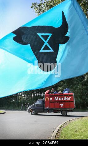 I manifestanti della ribellione animale si siedono su un camion serrato blasoned con McMurder sotto la bandiera della ribellione animale durante la protesta. Oltre 50 manifestanti della ribellione animale hanno chiuso l'unico impianto di distribuzione di hamburger di McDonald, la fabbrica di OSI Food Solutions nel Regno Unito bloccando l'ingresso con segnalatori e veicoli di bambù. I ribelli chiedono a McDonald di passare a menu completamente vegetali entro il 2025 e di porre fine alla sofferenza di miliardi di vite umane e di evitare la crisi climatica salvando la foresta pluviale amazzonica. (Foto di Martin Pope/SOPA Images/Sipa USA) Foto Stock