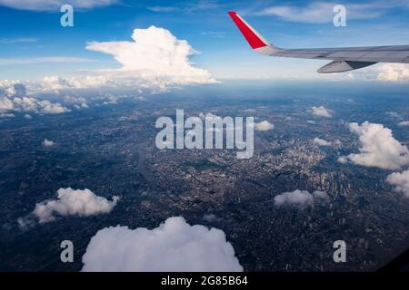 aletta rossa nel cielo blu scuro con vista sulla grande città sotto sotto sotto il sole Foto Stock