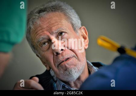 Uomo anziano con capelli bianchi e barba che chiede e fa una domanda su un nuovo soggetto nelle procedure mediche che sta per subire da un chirurgo Foto Stock