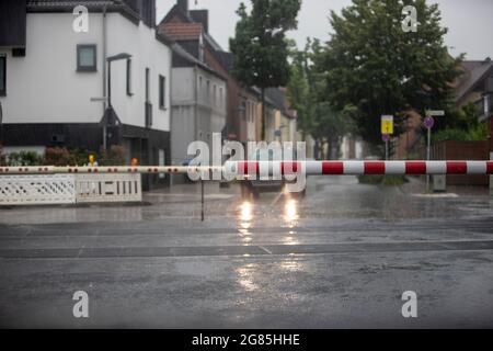 Huerth, NRW, Germania, 07 14 2021, pioggia pesante, auto in attesa di un passaggio in tram in città, la barriera è chiusa Foto Stock