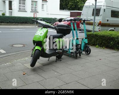 Colonia, Germania. 06 luglio 2021. Uno scooter elettrico del fornitore olandese 'GO Sharing' e scooters elettronici dallo stand Tier Mobility sul marciapiede sul lato della strada Credit: Horst Galuschka/dpa/Alamy Live News Foto Stock