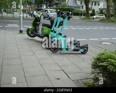 Colonia, Germania. 06 luglio 2021. Uno scooter elettrico del fornitore olandese 'GO Sharing' e scooters elettronici dallo stand Tier Mobility sul marciapiede sul lato della strada Credit: Horst Galuschka/dpa/Alamy Live News Foto Stock