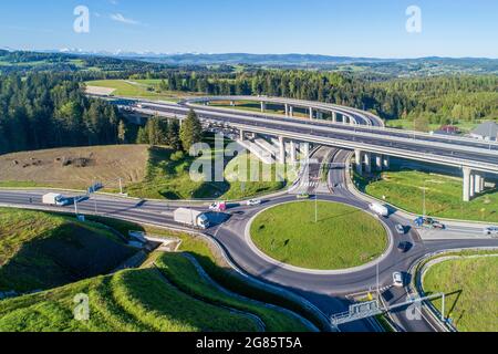 Nuova autostrada in Polonia sulla strada nazionale n. 7, E77, chiamata Zakopianka. Incrocio di cavalcavia con una rotonda, viadotti, strade di sicurezza, auto vicino Skomiel Foto Stock