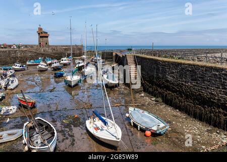 Marea fuori e le barche ormeggiate nel porto di Lynmouth con la storica Rhenish Tower sul molo. Exmoor National Park, Devon, Inghilterra, Regno Unito Foto Stock