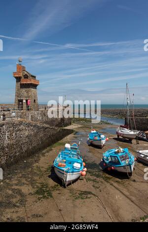 Marea fuori e le barche ormeggiate nel porto di Lynmouth con la storica Rhenish Tower sul molo. Exmoor National Park, Devon, Inghilterra, Regno Unito Foto Stock