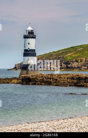 Faro di Pentmon a bassa marea con Puffin Island sullo sfondo, Anglesey, Galles del Nord Foto Stock