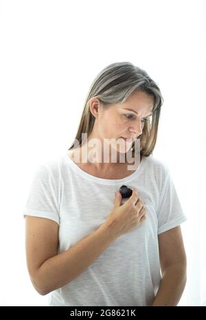 donna di mezza età con cristallo a forma di cuore. Concetto di amore di sé Foto Stock