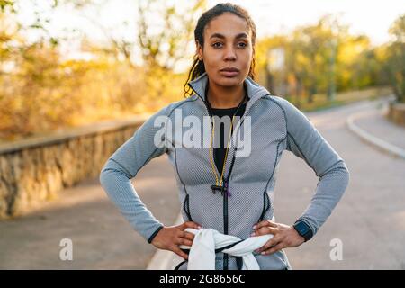 Sportivo afro-americano focalizzato in piedi mentre si allenano nel parco Foto Stock