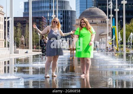 Birmingham, Regno Unito. 17 luglio 2021. I blogger Instagram Lauren B, 25, e Stacey Clarke, 37, si rinfrescano nella piscina della fontana nella Piazza Centenaria di Birmingham. Peter Lopeman/Alamy Live News Foto Stock