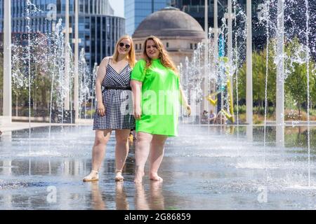 Birmingham, Regno Unito. 17 luglio 2021. I blogger Instagram Lauren B, 25, e Stacey Clarke, 37, si rinfrescano nella piscina della fontana nella Piazza Centenaria di Birmingham. Peter Lopeman/Alamy Live News Foto Stock
