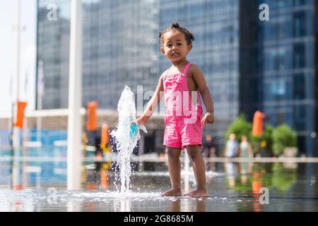 Birmingham, Regno Unito. 17 luglio 2021. Grace, di due anni, ha un po' di tempo nelle fontane della piazza del Centenario di Birmingham. Peter Lopeman/Alamy Live News Foto Stock