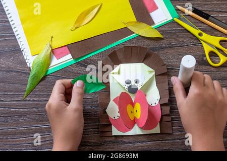 Istruzione, punto 10. Cartolina hedgehog con una mela su un tavolo di legno. Fatto a mano. Progetto di creatività per bambini, artigianato, artigianato per bambini. Foto Stock