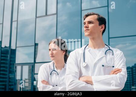 immagine dei medici che si trovano di fronte all'edificio dell'ospedale. Foto Stock