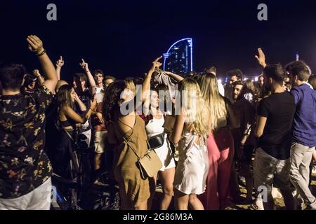 Barcellona, Spagna. 16 luglio 2021. Sulla spiaggia di Barceloneta, di fronte all'Hotel W Barcelona, si trova una folla di giovani. La polizia evica le folle dalla spiaggia di Barceloneta dopo che la Catalogna decretò il ritorno del coprifuoco dato il rimbalzo in casi COVID-19 come risultato della variante delta del coronavirus. Il coprifuoco inizierà dalle ore 1:00 del 17 luglio. (Foto di Thiago Prudencio/SOPA Images/Sipa USA) Credit: Sipa USA/Alamy Live News Foto Stock