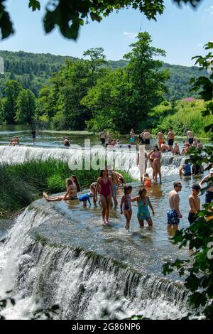 La gente apprezza l'acqua al Warleigh Weir sul fiume Avon vicino a Bath nel Somerset mentre le temperature si innalzano attraverso il Regno Unito. Foto Stock