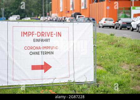 Berlino, Germania. 17 luglio 2021. Una lunga coda si forma di fronte al drive-in vaccinale presso il ramo di Ikea a Lichtenberg davanti al cartello con la scritta 'Impf-Drive-in Einfahrt Corona-Impfung Ohne Termin'. Nel parcheggio del negozio Ikea di Lichtenberg, chiunque può essere vaccinato spontaneamente senza appuntamento. Credit: Fabian Sommer/dpa/Alamy Live News Foto Stock