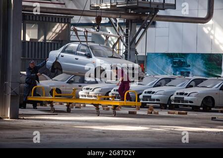 Kostanay,Kazakhstan,May14,2012:Saryarkaavtoprom impianto di auto-costruzione. Produzione di automobili ZAZ Chance. Spostamento del cassone dell'auto sul paranco in posizione di assemblaggio. Foto Stock