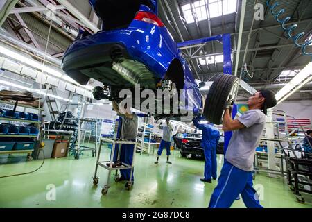 UST'-Kamenogorsk, Kazakhstan - Maggio 31,2012: Stabilimento di auto-costruzione della società Asia-Auto. Montare la ruota da un operatore. Linea di trasportatori per il montaggio di automobili KIA MOTORS. Foto Stock