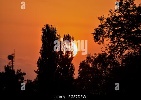 Srinaga, India. 17 luglio 2021. Il sole tramonta dopo una calda giornata estiva a Srinagar. (Immagine di credito: © Saqib Majeed/SOPA Images via ZUMA Press Wire) Foto Stock