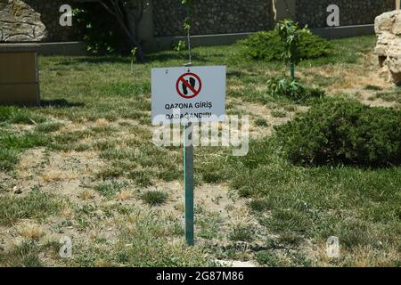 Cartello con il simbolo non camminare sull'erba . Segnale di stop, accesso vietato. Non incrociare. Cartello di divieto su corda . Accesso al prato Foto Stock