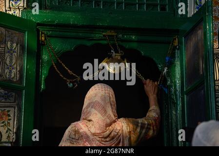Srinagar, India. 17 luglio 2021. Una donna musulmana del Kashmiri prega fuori dal santuario di Sufi San Syed Ali Hamadani durante i suoi urs a Srinagar.centinaia di musulmani del Kashmiri si sono riuniti a Shrines per commemorare l'anniversario della morte di un famoso santo sufi, Mir Syed Ali Hamadani. Credit: SOPA Images Limited/Alamy Live News Foto Stock