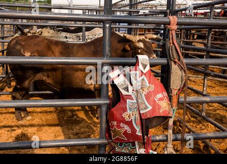 Bloomington, Stati Uniti. 02 luglio 2021. Un giubbotto protettivo per rodeo è appeso alla recinzione intorno al bull PEN 3 Bar J Rodeo alla fiera della contea di Monroe. La fiera della contea di Monroe a Bloomington, Indiana, è una mostra annuale di artigianato, prodotti agricoli e bestiame durante la settimana, un raduno della comunità e un festival che si tiene nella zona fieristica della contea. Le fiere della contea negli Stati Uniti sono una tradizione e una parte della cultura profondamente radicata nella vita rurale americana. Le fiere della contea sono iniziate molto tempo fa come un modo per gli agricoltori e i lavoratori agricoli di riunirsi e socializzare. Credit: SOPA Images Limited/Alamy Live News Foto Stock