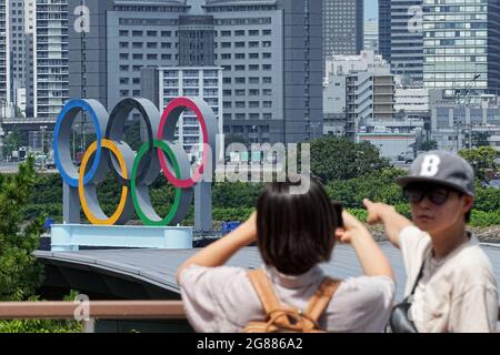 Tokio, Giappone. 18 luglio 2021. Due persone scattano una foto di se stessi davanti agli anelli olimpici. Le Olimpiadi di Tokyo 2020 si terranno dal 23.07.2021 al 08.08.2021. Credit: Michael Kappeler/dpa/Alamy Live News Foto Stock