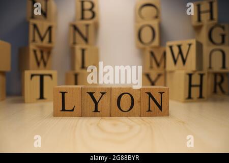 La parola Lione è stata creata da cubi di lettere di legno. Città e parole. Primo piano. Foto Stock