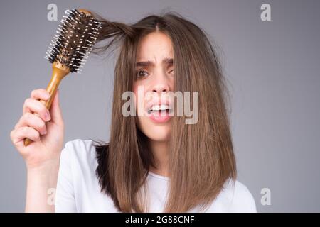 Perdita dei capelli del closeup, caduta dei capelli nel hairbrush, problema di sforzo della donna con un pettine. Foto Stock