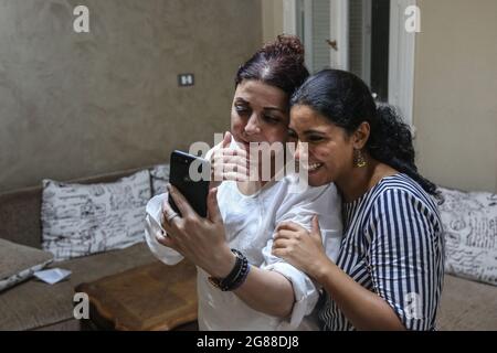 Cairo, Egitto. 18 luglio 2021. L'attivista e giornalista egiziano Esraa Abdel Fattah (L) si pone per una foto con l'amico a casa sua dopo essere stato rilasciato dalla prigione. Esraa è detenuta in stato di detenzione preventiva sin dal suo arresto nell'ottobre 2019 con l'accusa di diffondere notizie false e di partecipare a un gruppo terroristico per il raggiungimento dei suoi obiettivi. Credit: Mohamed El Raai/dpa/Alamy Live News Foto Stock