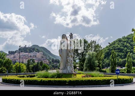 La statua di Santa Rita da Cascia accoglie i fedeli all'ingresso del paese, Cascia, Italia Foto Stock