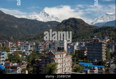 Il paesaggio urbano di Pokhara con la catena montuosa dell'Annapurna coperta di neve nel Nepal centrale, in Asia Foto Stock