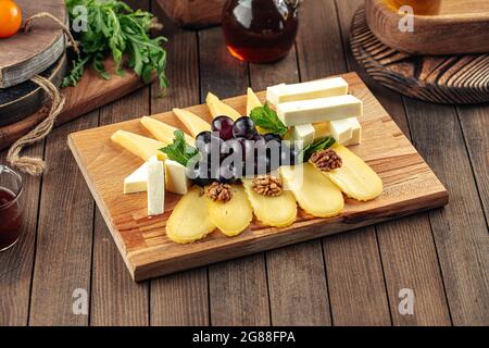 Piatto assortito di antipasti al formaggio con uva Foto Stock