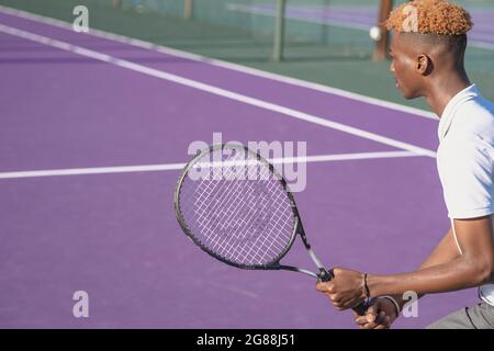 Vista posteriore del giovane che gioca a tennis Foto Stock