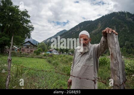 Bandipora, India. 18 luglio 2021. Un uomo guarda come lavora nel suo campo in una giornata di sole nella Valle di Gurez.Gurez si trova lungo il LOC nella parte settentrionale del Kashmir. Gurez è una valle situata nell'alta Himalaya, a circa 123 chilometri da Srinagar nel nord del Kashmir. A circa 2,400 metri sul livello del mare, la valle è circondata da montagne innevate. Credit: SOPA Images Limited/Alamy Live News Foto Stock