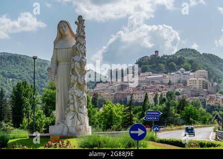 La statua di Santa Rita da Cascia accoglie i fedeli all'ingresso del paese, Cascia, Italia Foto Stock