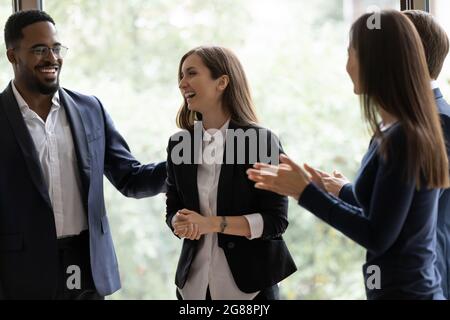 Felice team di business diversi applaudendo il successo dei colleghi Foto Stock