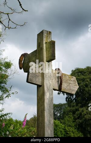Un fingerpost di legno su un sentiero a Huntington, Herefordshire, Inghilterra, Regno Unito. Due vecchi e arrugginiti ferro di cavallo sono appesi da esso come un fascino di buona fortuna Foto Stock