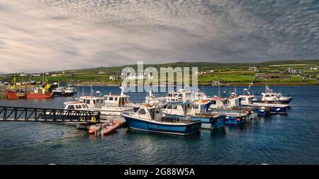 Vista panoramica del porto nel villaggio irlandese di Portmagee nella contea di Kerry, con diverse barche da pesca in primo piano. Foto Stock