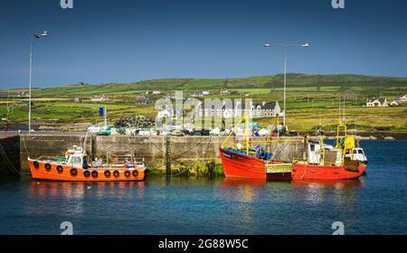 Vista panoramica del porto nel villaggio irlandese di Portmagee nella contea di Kerry, con diverse barche da pesca in primo piano. Foto Stock