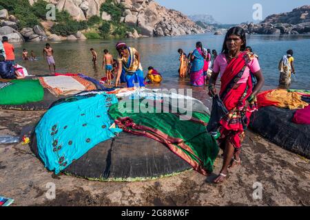 Hampi, Karnataka, India - 10 gennaio 2020 : persone che si bagnano e si preparano sulle rive del fiume Tungabhadra nella città di Hampi. Foto Stock