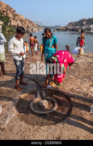 Hampi, Karnataka, India - 10 gennaio 2020 : persone che si bagnano e si preparano sulle rive del fiume Tungabhadra nella città di Hampi. Foto Stock
