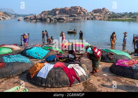 Hampi, Karnataka, India - 10 gennaio 2020 : persone che si bagnano e si preparano sulle rive del fiume Tungabhadra nella città di Hampi. Foto Stock