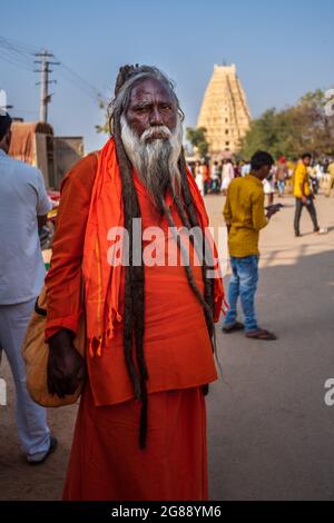 Hampi, Karnataka, India - 11 gennaio 2020 : UN monaco in abiti arancioni si trova di fronte al Tempio di Virupaksha. Foto Stock