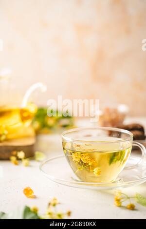 Tazza di tè alle erbe con fiori di tiglio su sfondo bianco Foto Stock