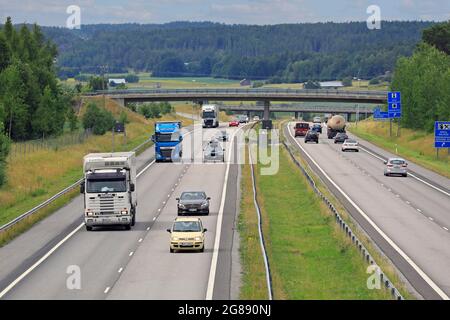 Traffico in autostrada con camion e auto in un pomeriggio estivo soleggiato. Strada nazionale finlandese 1, E18, Salo, Finlandia. 9 luglio 2021. Foto Stock