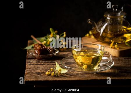 Tazza di tè alle erbe con fiori di tiglio su sfondo scuro Foto Stock