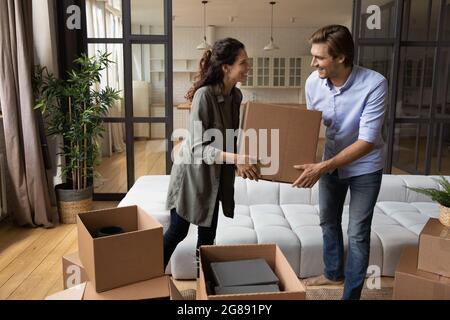 Moglie di marito millennial che trasporta le scatole con roba al nuovo appartamento Foto Stock