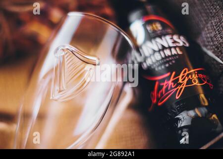 Lviv, Ucraina - 1° dicembre 2017: Bottiglia di birra Guinness, bicchiere di vetro sul burlap in confezione regalo. Messa a fuoco morbida. Elegante confezione regalo per il compleanno dell'uomo, il giorno dei padri. G Foto Stock